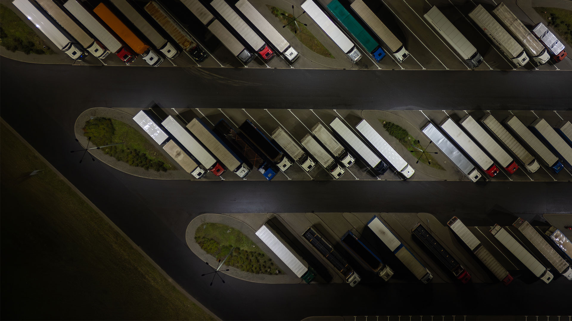 Aerial view of semi trucks parked at a truck stop at night